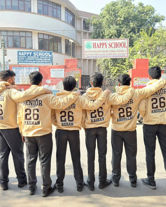 Senior batch '26 students in sand hoodies with names printed on the back